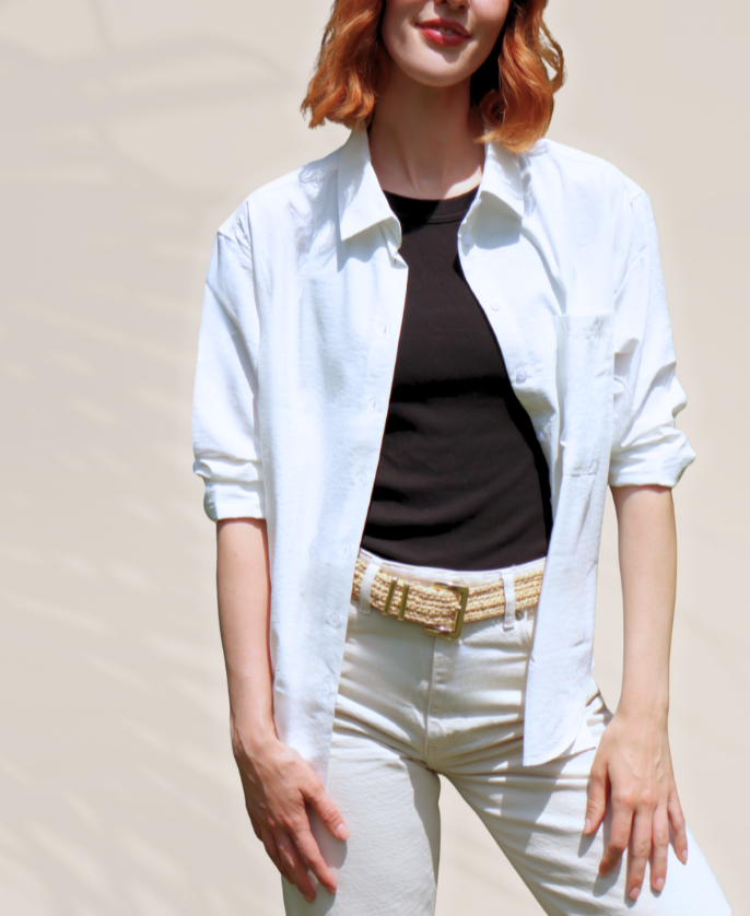 Person wearing a UPF white shirt, black top, and white pants against a beige background